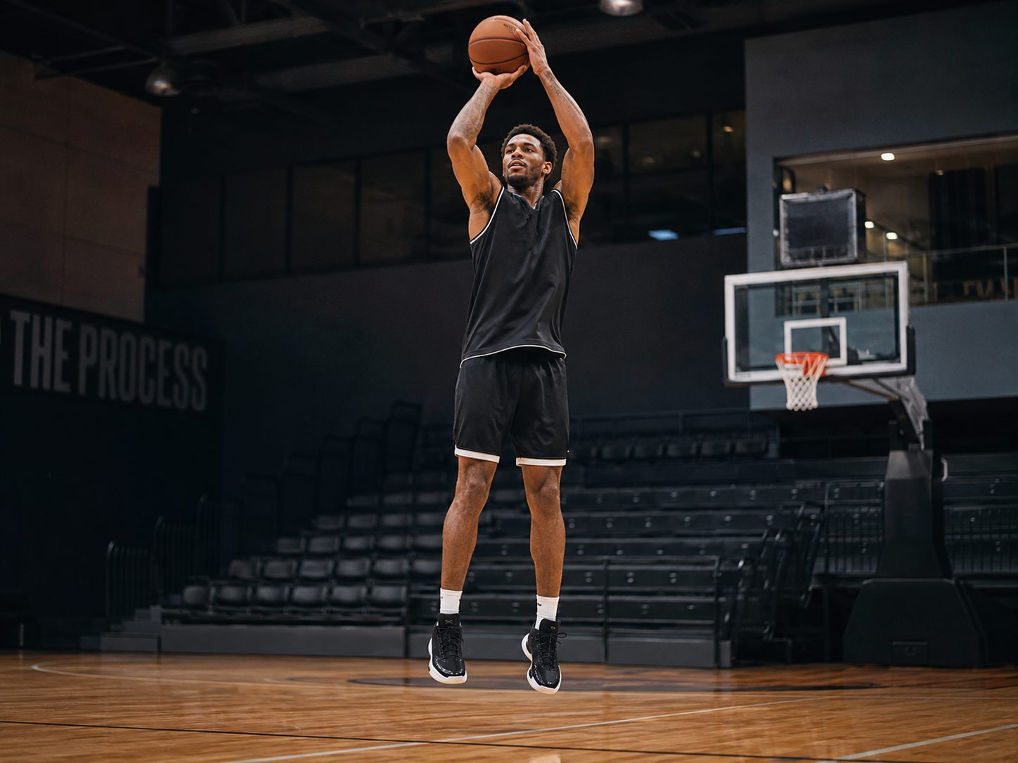 Professional basketball player mid-jump shot in an arena